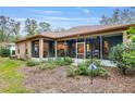 View of the home's screened lanai with views into the home from the outside and lush greenery at 19586 Sw 84Th Pl, Dunnellon, FL 34432
