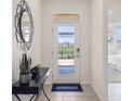 Bright foyer features a stylish mirror, a console table, and a view to the backyard at 3066 Canopy Oak Blvd, Wildwood, FL 34785