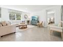 Bright living room featuring tile floors, ample seating, neutral color palette, and an open, airy feel at 3125 Evenmore Way, Wildwood, FL 34785