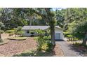 Landscaped single-story home featuring beautiful trees and a winding driveway at 4701 Nw 60Th Terrace, Ocala, FL 34482