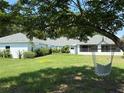 Spacious backyard featuring lush green grass and a hammock under a mature tree at 6925 Nw Highway 225A, Ocala, FL 34482