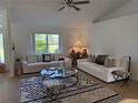 Bright living room with two white sofas, modern rug, and large window offering natural light at 6925 Nw Highway 225A, Ocala, FL 34482