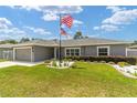 Beautiful one-story home with gray stucco and manicured front yard under a bright sky at 7442 Sw 129Th Ln, Ocala, FL 34473