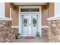 Close-up of the home's front door with stone accents and decorative glass at 12804 Se 90Th Court Rd, Summerfield, FL 34491