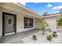 Close up of an entrance featuring decorative rock landscaping and a gray front door at 15350 Sw 30Th Street, Ocala, FL 34481