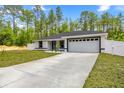New construction featuring a manicured lawn, two-car garage, and fresh landscaping at 15350 Sw 30Th Street, Ocala, FL 34481