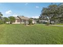 Single Gathering home featuring a lush lawn, mature trees, and inviting curb appeal at 2208 Orkney Dr, Leesburg, FL 34788