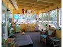 Enclosed porch features wicker furniture, plants and decor, offering a cozy and inviting space to relax and enjoy the outdoors at 22736 Sw 117Th St, Dunnellon, FL 34431