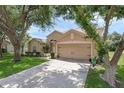 Charming single-story home with a well-manicured lawn, lush landscaping and a 2 car garage at 2434 Walnut Heights Rd, Apopka, FL 32703
