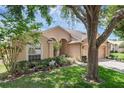 Charming single-story home with a well-manicured lawn, lush landscaping and a 2 car garage at 2434 Walnut Heights Rd, Apopka, FL 32703