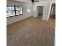 Open living room with tile floors, bright windows, and a ceiling fan at 3740 Ne 5Th St, Ocala, FL 34470