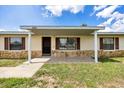 Inviting covered front porch with stone accents, offering a welcoming entrance to the home at 4331 Se 106Th Pl, Belleview, FL 34420
