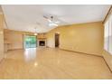 Spacious living room featuring a stone fireplace, wood floors and a ceiling fan at 4331 Se 106Th Pl, Belleview, FL 34420