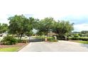 Gated community entrance with stone pillars and lush green trees at 4990 Sw 63Rd Loop, Ocala, FL 34474