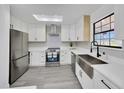 Bright kitchen with stainless steel appliances, white cabinets, and skylight at 6 Bahia Circle Loop, Ocala, FL 34472