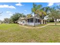 Inviting single-Gathering home featuring a screened porch, mature trees, and a carport at 705 Washington Ave, Eustis, FL 32726