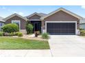 Charming home exterior with a manicured lawn and a two-car garage, great curb appeal and design at 7333 Sw 98Th Ct, Ocala, FL 34481