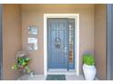 Charming front door with a decorative wreath, surrounded by potted plants and stylish exterior decor at 7333 Sw 98Th Ct, Ocala, FL 34481