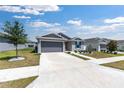 Attractive single-story home with gray siding, a two-car garage, and a manicured lawn at 7571 Sw 64Th Street Rd, Ocala, FL 34474