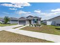 Inviting single-story house featuring gray siding, a two-car garage, and a landscaped front yard at 7571 Sw 64Th Street Rd, Ocala, FL 34474