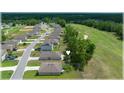 An aerial view of a golf course community featuring single Gathering homes and a lush green fairway, backing up to tree line at 96 Hickory Crse, Ocala, FL 34472