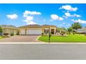 Inviting exterior featuring a three car garage and well maintained landscape at 11871 Se 91St Cir, Summerfield, FL 34491