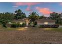 Charming single-story home featuring a well-manicured lawn and a palm tree in the front yard at 12495 Sw 66Th St, Ocala, FL 34481