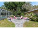 Outdoor fire pit area with chairs for gathering, set near a screened-in pool area at 12495 Sw 66Th St, Ocala, FL 34481
