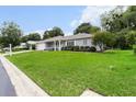 Well-maintained home with vibrant green lawn, mature trees, and inviting curb appeal at 14481 Sw 112Th Cir, Dunnellon, FL 34432