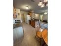 Functional kitchen with tiled flooring, sink with window and bar stool seating at 24 Malauka Ter, Ocklawaha, FL 32179