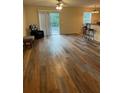 Cozy living room featuring modern flooring, a ceiling fan, and sliding glass doors to the backyard at 24 Malauka Ter, Ocklawaha, FL 32179