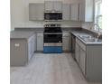 Modern kitchen with gray cabinets, stainless steel appliances, and sleek countertops at 2825 Sw 147Th Ct, Ocala, FL 34481