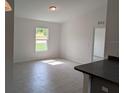 Bright living room with light tile floors, large window, and neutral paint at 2825 Sw 147Th Ct, Ocala, FL 34481