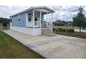 Stylish single-story park model with a covered porch and concrete parking pad at 4345 Nw 27Th Pl, Ocala, FL 34482