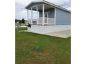 Quaint cottage featuring a cozy porch, complemented by lush green grass and outdoor seating area at 4345 Nw 27Th Pl, Ocala, FL 34482