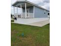 Exterior view of a cottage with covered porch, showcasing manicured lawn and charming community at 4345 Nw 27Th Pl, Ocala, FL 34482