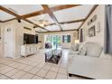 Spacious living room with tile floors, wood beam ceilings, and access to the outdoor deck at 531 Ne 142Nd Ave, Silver Springs, FL 34488