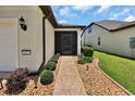 Inviting front entrance with a stone walkway, decorative landscaping, and a screened porch at 6051 Sw 93Rd Cir, Ocala, FL 34481