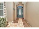 Elegant entryway featuring a decorative glass front door and brick-paved path at 7210 Sw 179 Ct, Dunnellon, FL 34432