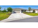 Landscaped front yard with mature trees and green lawn leading to a single-story home with a two-car garage at 7750 Sw 87Th Ave, Ocala, FL 34481