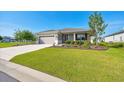 Inviting single-Gathering home with a well-kept lawn, colorful landscaping, and a spacious driveway leading to the garage at 7750 Sw 87Th Ave, Ocala, FL 34481