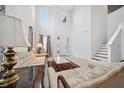 Bright living room with high ceilings, tile floors, elegant decor, and staircase at 8110 Sw 59Th Ter, Ocala, FL 34476