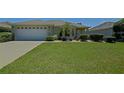 Welcoming single-story home showcasing a well-maintained lawn, an attached two-car garage and manicured landscaping at 9068 Se 120Th Loop, Summerfield, FL 34491