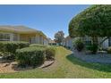 View of the side yard showing manicured hedges and a grassy area between two homes at 9068 Se 120Th Loop, Summerfield, FL 34491