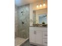 Bathroom features a tiled walk-in shower, vanity with granite counters, and updated lighting fixtures at 960 Nw Redwood Dr, Dunnellon, FL 34431