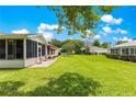 Expansive backyard featuring a well-maintained lawn, screened patio and mature landscaping at 9891 Se 138Th Loop, Summerfield, FL 34491