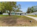 Cozy one-story home featuring tidy front lawn and a single car garage with blue and white accents at 111 Almond Rd, Ocala, FL 34472