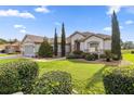 Inviting single-story home showcasing mature landscaping and a well-maintained green lawn at 13015 Se 93Rd Cir, Summerfield, FL 34491