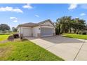 Detached two-car garage with an extended driveway and mature landscaping at 13015 Se 93Rd Cir, Summerfield, FL 34491