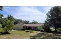 Inviting single-story home with a well-maintained yard and two chairs on the front lawn at 13385 Ne 10Th Ct, Citra, FL 32113